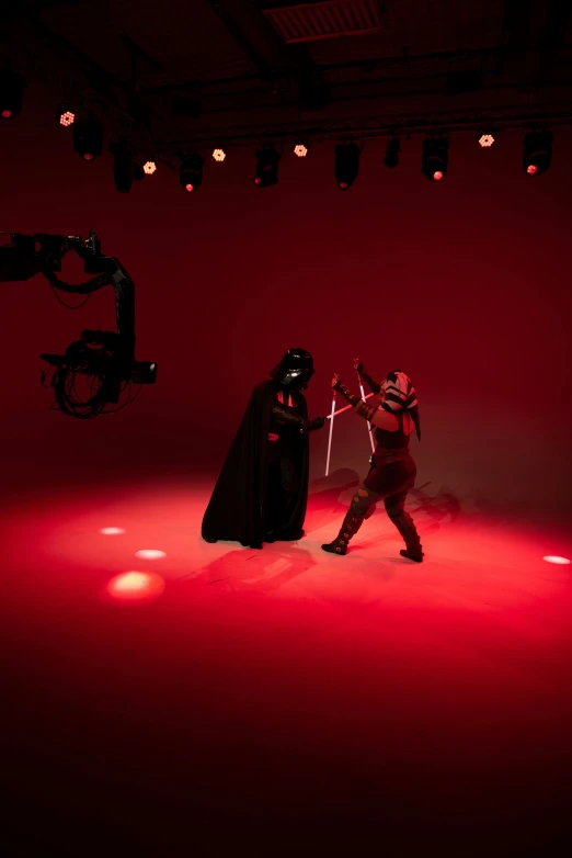 a couple of people standing on top of a stage, fighting darth vader, general studio lighting, shot on red camera, taken with sony alpha 9