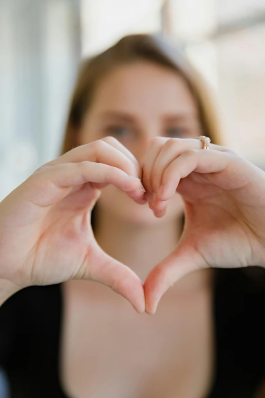 a woman making a heart with her hands, pexels, avatar image, large)}], half - length photo, kind