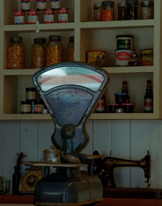 a scale sitting on top of a wooden counter, by Jessie Algie, pexels contest winner, photorealism, inside an old magical sweet shop, retro machinery, front lit, convenience store