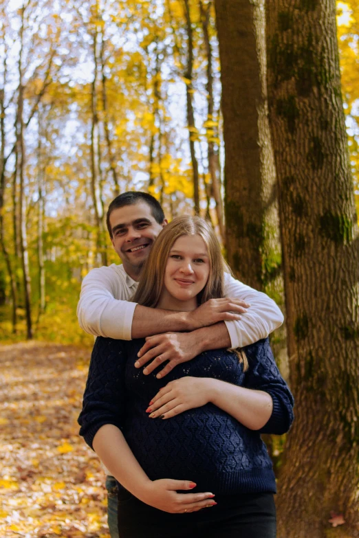 a pregnant woman standing next to a man in a forest, a picture, 15081959 21121991 01012000 4k, petros and leonid, autum, hugging