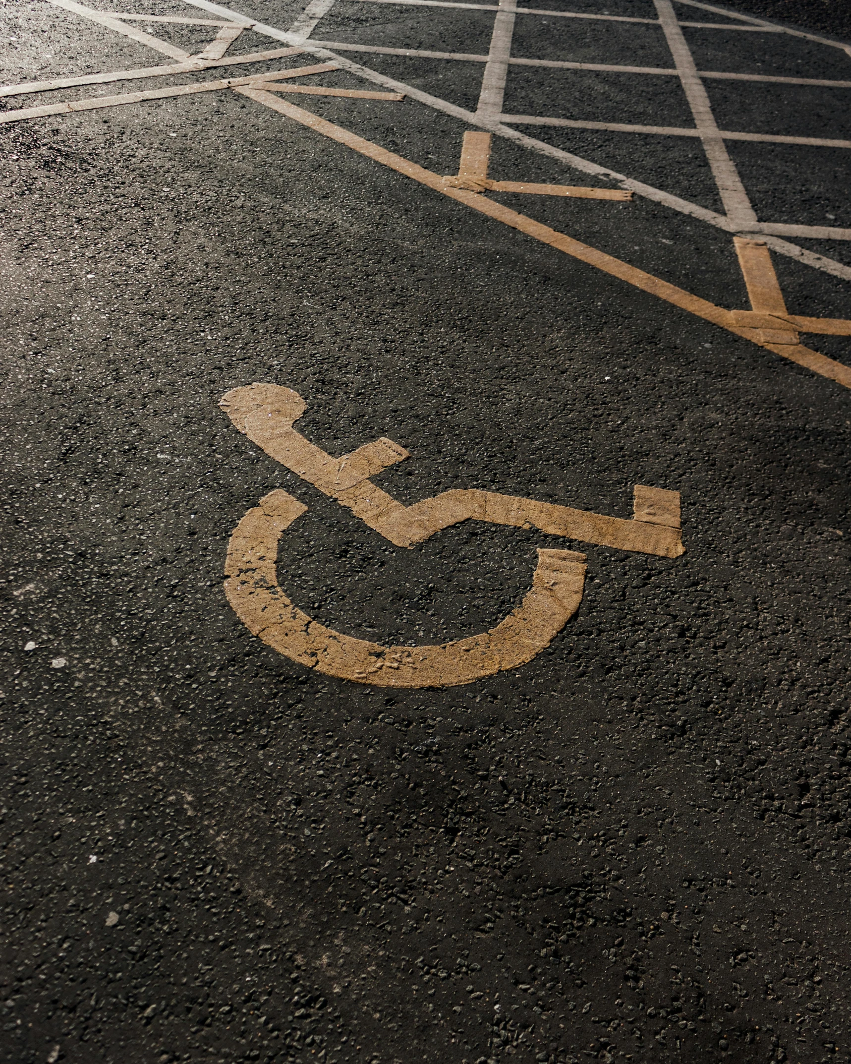 a parking lot with a handicap sign painted on it, trending on pexels, lgbtq, concrete poetry, background image, leaked photo