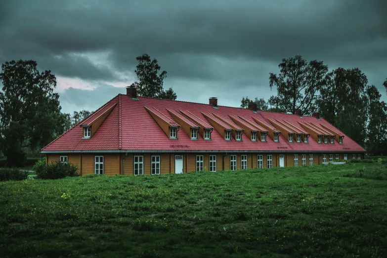 a house sitting on top of a lush green field, a portrait, by Jesper Knudsen, pexels contest winner, art nouveau, barracks, overcast dusk, red trusses, school