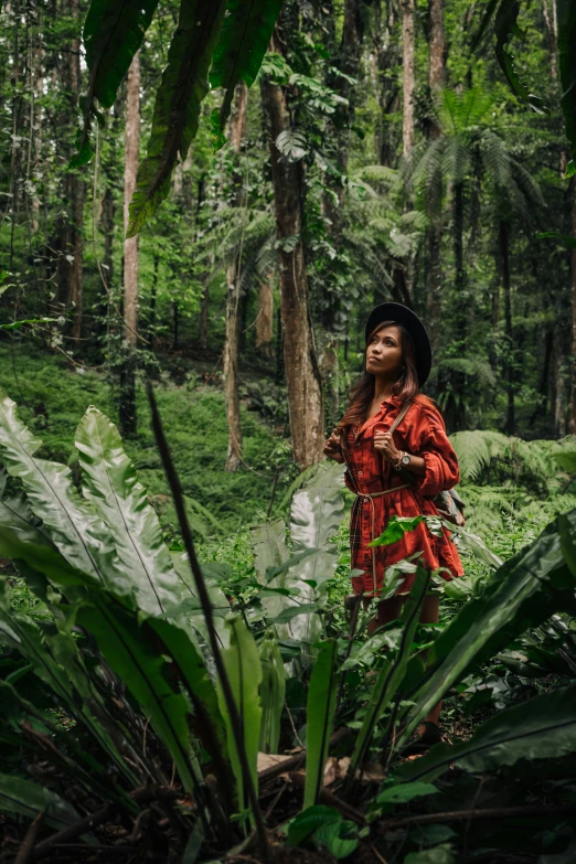 a woman walking through a lush green forest, an album cover, pexels contest winner, sumatraism, tribal clothing, malaysia jungle, sza, american astronaut in the forest