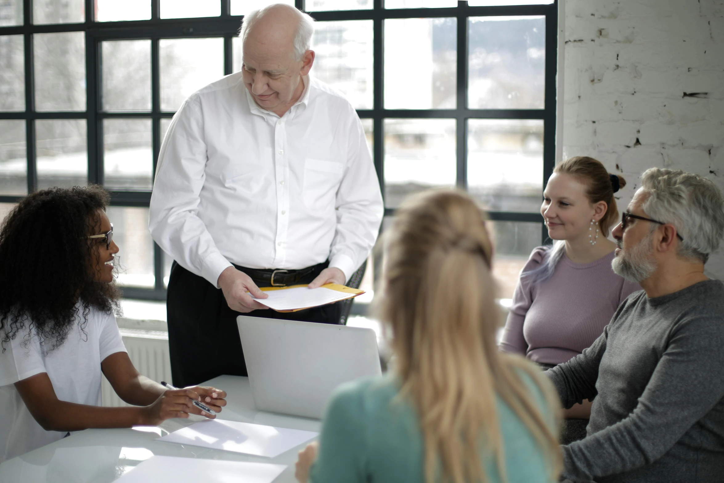 a group of people sitting around a table, on a desk