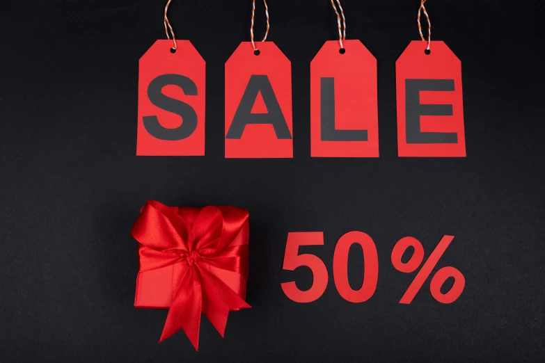 sale tags and a red bow on a black background, pixabay, 50 years old, thumbnail, 50, very grainy image