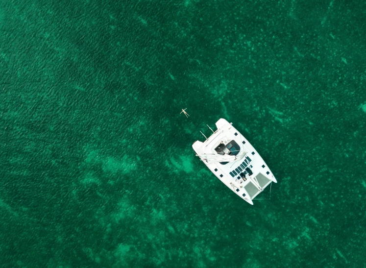 a white boat floating on top of a body of water, by Emma Andijewska, pexels contest winner, green ocean, top - down photo, relaxing on a yacht at sea, deep colour