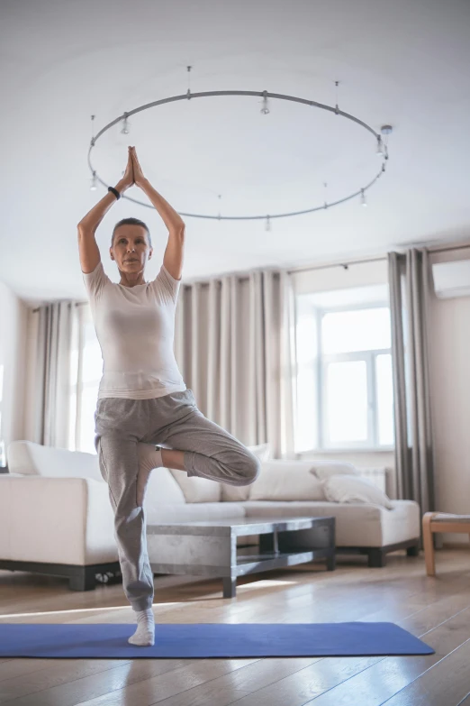 a woman doing yoga in a living room, by Adam Marczyński, pexels contest winner, arabesque, halo above head, centered full body pose, 15081959 21121991 01012000 4k, circular