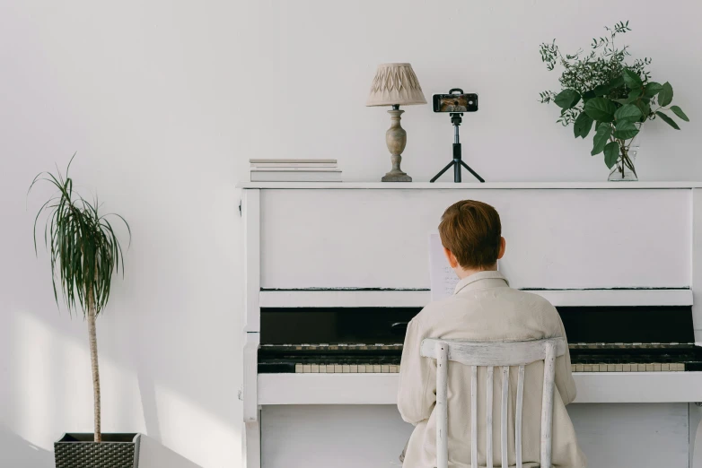 a person sitting at a piano in a room, inspired by Wilhelm Hammershøi, trending on pexels, white, background image, white table, white finish