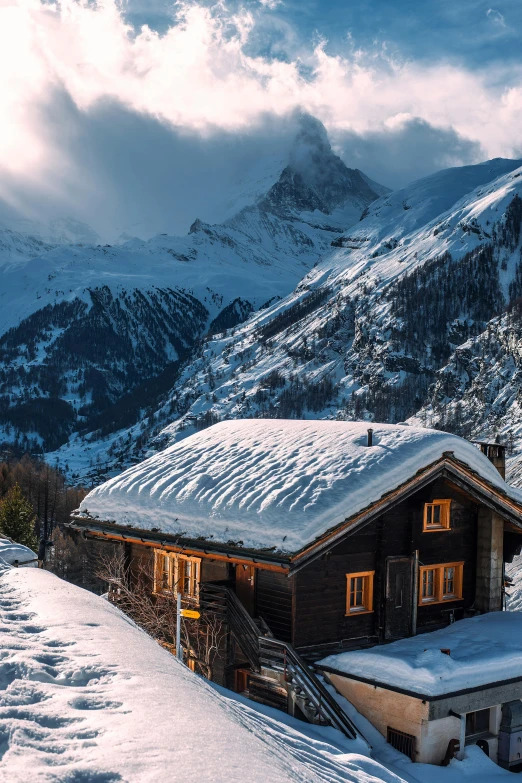 a house sitting on top of a snow covered slope, by Daniel Seghers, pexels contest winner, dramatic mountains behind, gnomon, cozy setting, panorama