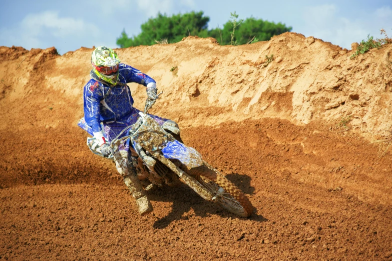 a person riding a dirt bike on a dirt track, by Federico Zuccari, shutterstock, figuration libre, tournament, blue, brown, university