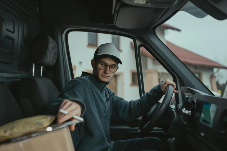 a man sitting in the driver's seat of a truck, pexels contest winner, delivering parsel box, avatar image, portrait image
