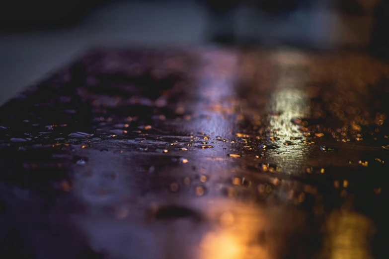 a close up of a wet surface with a street light in the background, unsplash, art photography, gold and purple, metal plate photograph, warm glow coming the ground, overcast bokeh - c 5