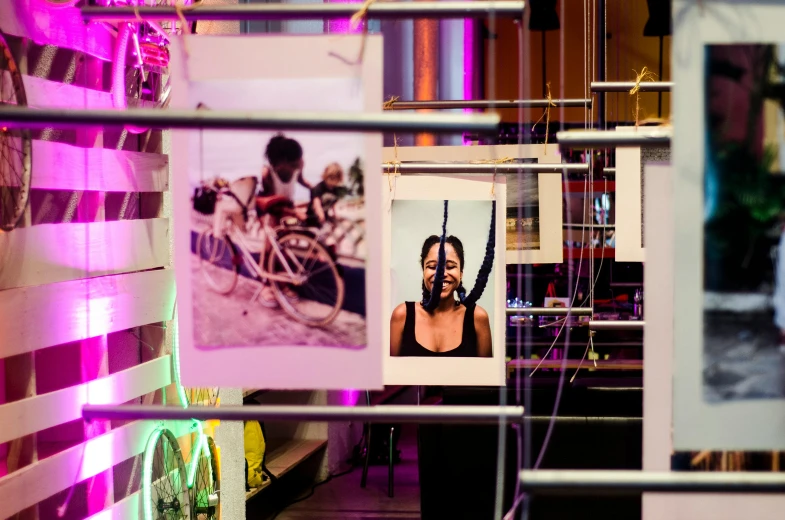 a couple of pictures hanging on a wall, a portrait, unsplash, process art, neon standup bar, photo of a black woman, event photography, wrapped in wires and piones