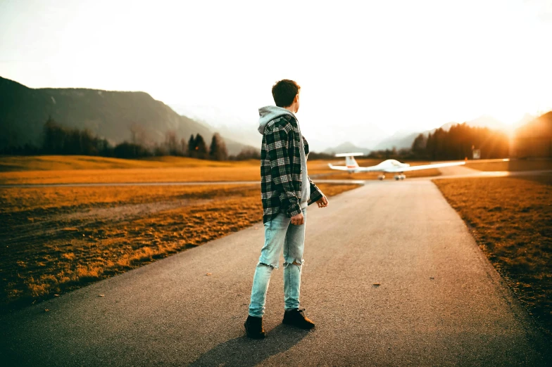 a man standing in the middle of a road, airplanes, teenager, profile picture 1024px, easygoing