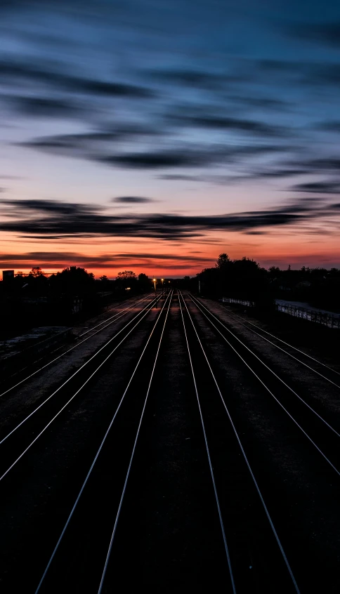 a train track with a sunset in the background, an album cover, unsplash, on black background, instagram photo, outdoor photo, multiple stories