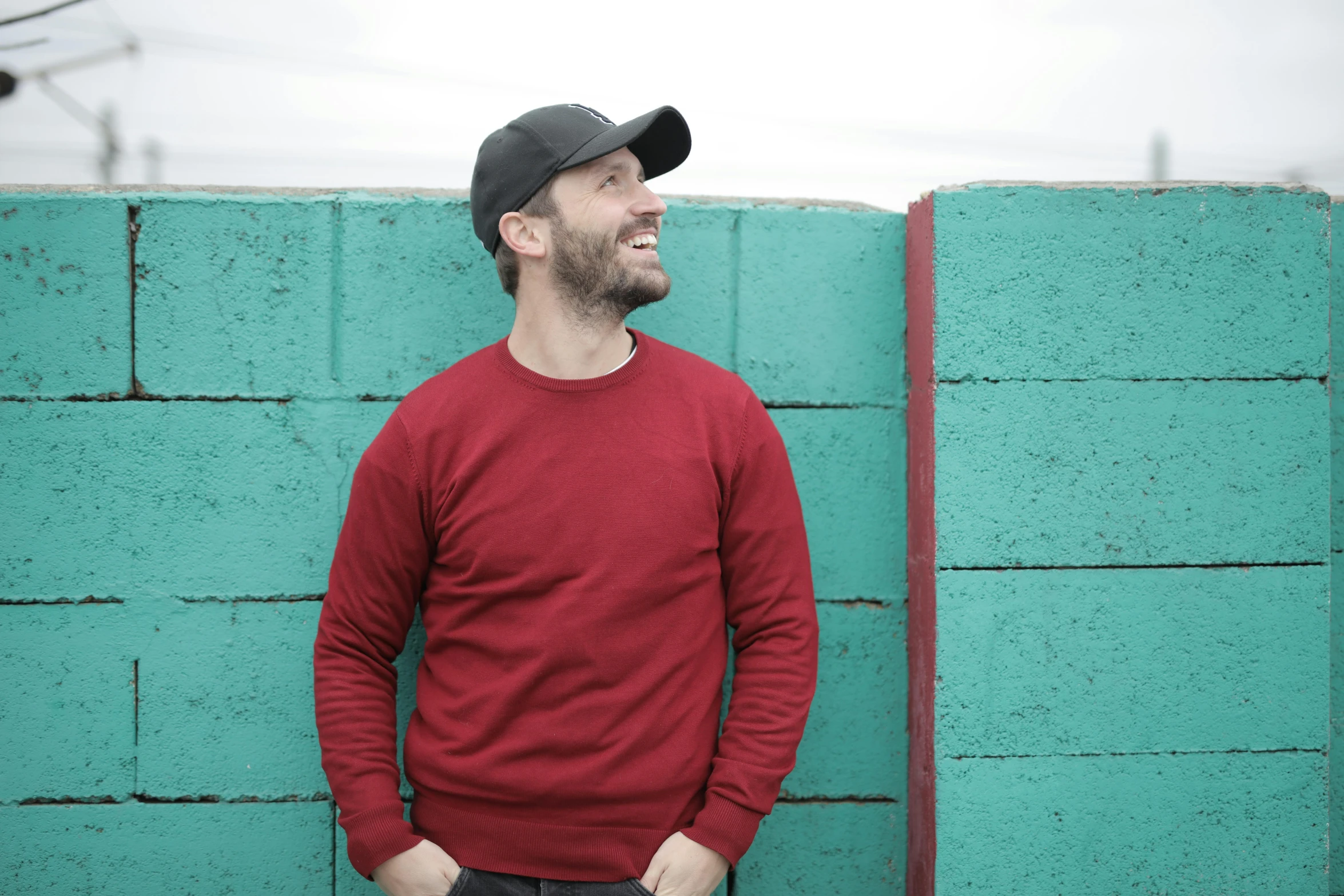 a man standing in front of a green wall, an album cover, pexels contest winner, red sweater and gray pants, laughing, profile image, standing on rooftop