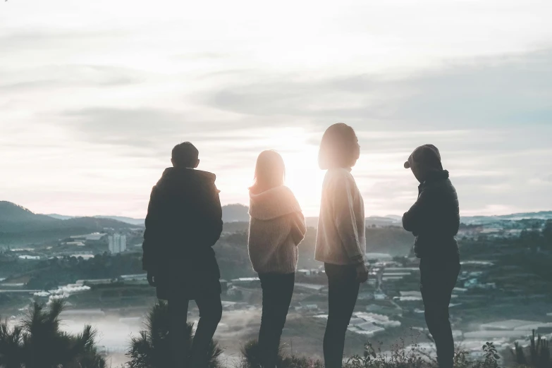 a group of people standing on top of a hill, by Emma Andijewska, pexels contest winner, college girls, back lit, looking off to the side, roomies