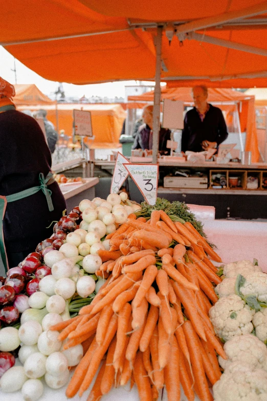 a table topped with lots of different types of vegetables, a photo, by Jan Tengnagel, unsplash, market stalls, orange and white color scheme, square, canopies