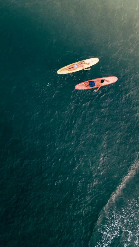 a couple of people riding surfboards on top of a wave, pexels contest winner, minimalism, some boats, low quality photo, thumbnail, top - down photo