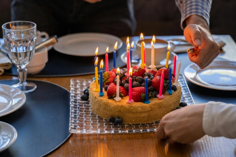 a person lighting candles on a birthday cake, an album cover, by Daniel Gelon, pexels, fan favorite, edible, half image, high quality upload