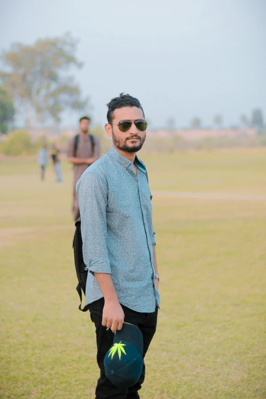 a man standing in a field holding a frisbee, a picture, by Riza Abbasi, low quality photo, ((portrait)), at college, **cinematic