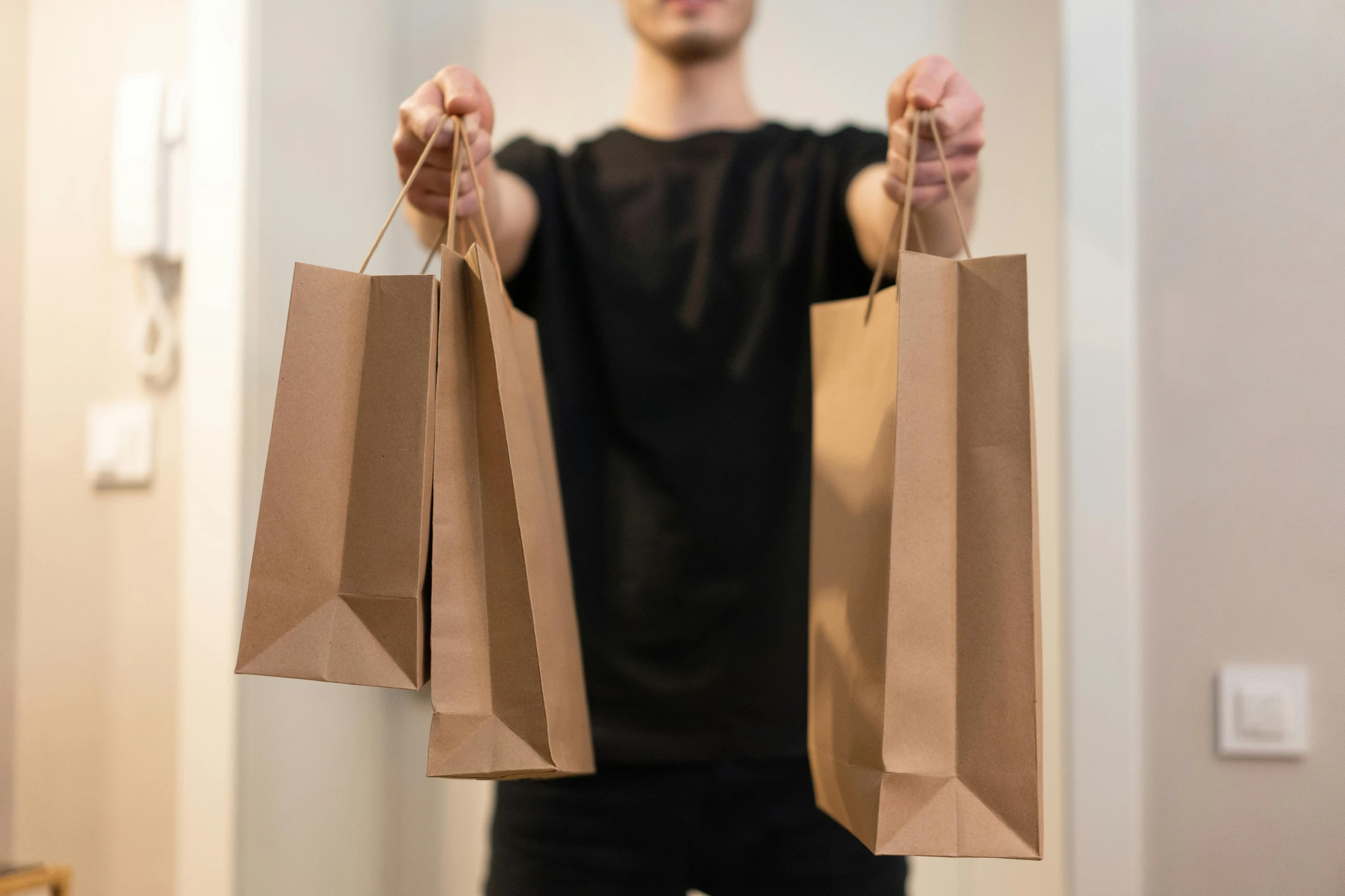 a man holding two shopping bags in his hands, pexels contest winner, brown paper, official store photo, lachlan bailey, packaging design