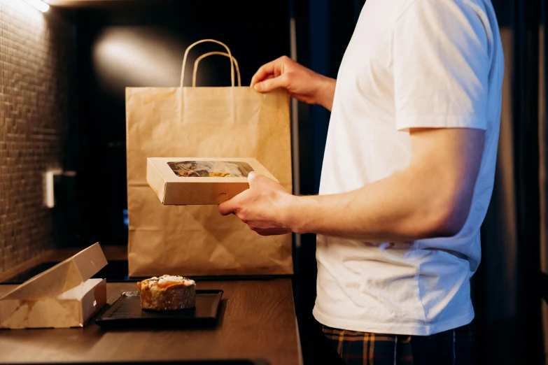 a man standing in front of a counter with a bag of food, pexels contest winner, renaissance, delivering parsel box, pastry, lachlan bailey, avatar image