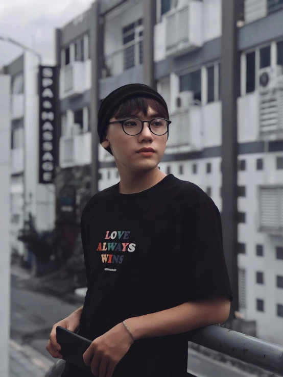 a young man standing in front of a tall building, inspired by Ion Andreescu, unsplash contest winner, lesbians, jakarta, embroidered shirt, wearing black glasses