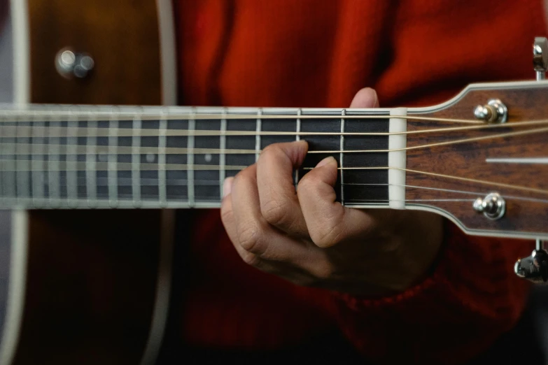 a close up of a person playing a guitar, inspired by John McLaughlin, unsplash, photorealism, slightly red, close-up of thin soft hand, thumbnail, kenne gregoire