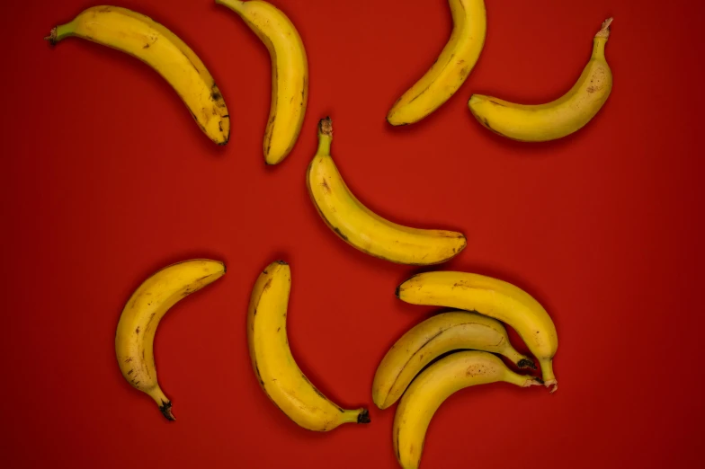 a group of bananas sitting on top of a red surface