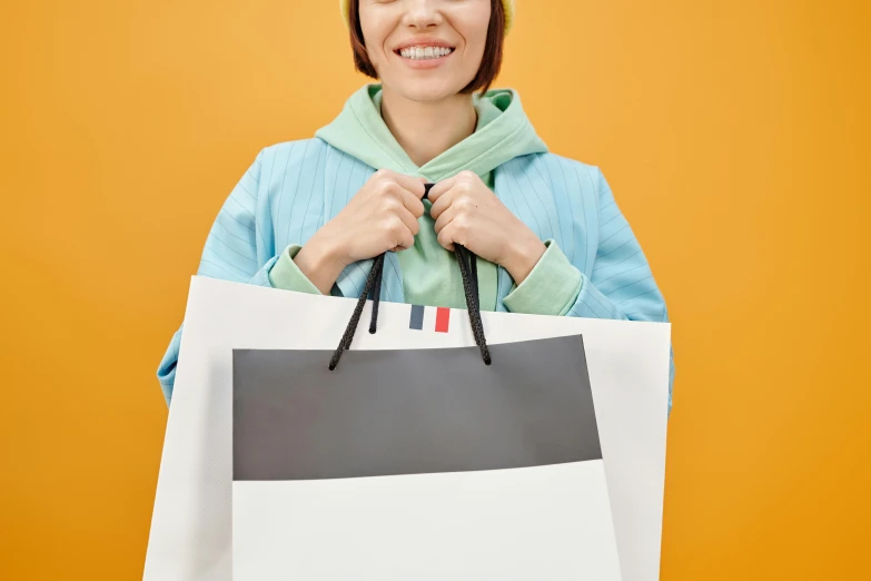 a woman holding a shopping bag and smiling, by Julia Pishtar, trending on pexels, suprematism, white french bob, wearing a yellow hoodie, nishimiya shouko, plain background