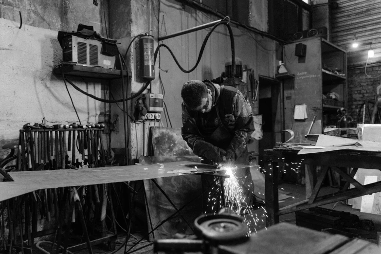 a man welding a piece of wood in a workshop, by Kristian Zahrtmann, pexels, arbeitsrat für kunst, black and white artistic photo, steel and metal, anna nikonova, made of steel