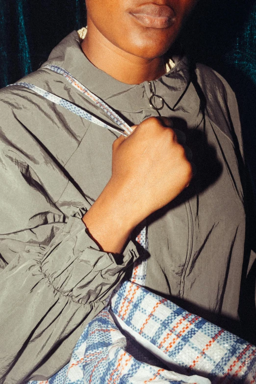 a close up of a person holding a purse, by Alexander Mann, on the tennis coat, imaan hammam, gray shirt, detail shot