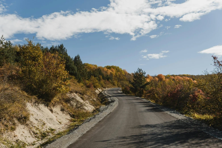 a man riding a skateboard down a curvy road, a picture, by Julia Pishtar, unsplash contest winner, les nabis, vermont fall colors, panorama, stony road, high quality product image”