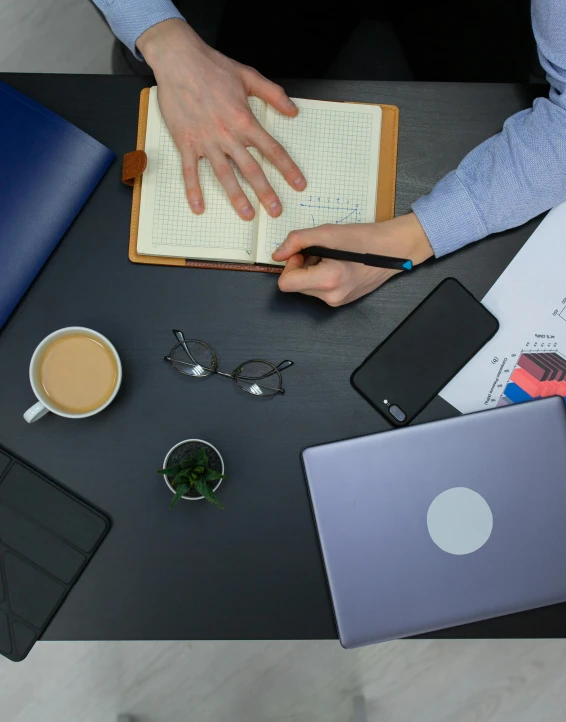 a couple of people sitting at a table with laptops, trending on pexels, is being drawn into a blackhole, writing in journal, offices, 9 9 designs