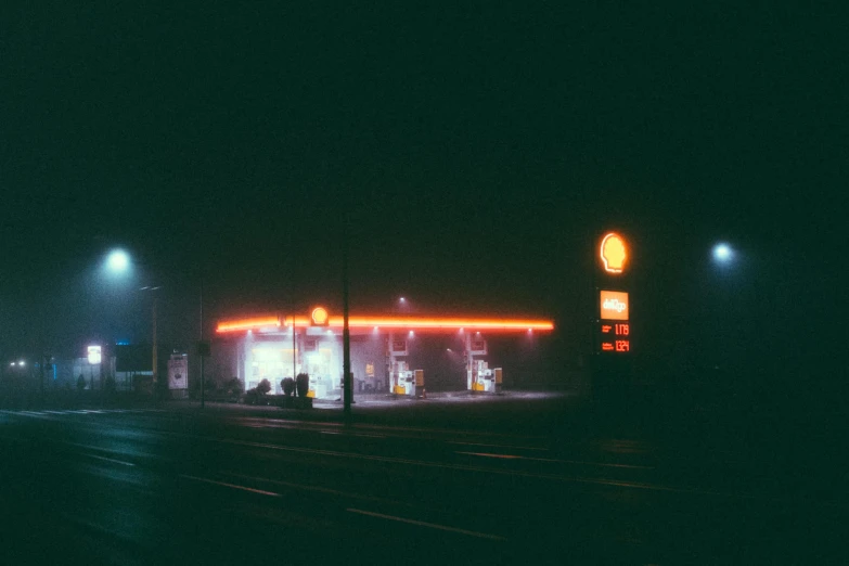 a gas station in the dark at night, a polaroid photo, inspired by Elsa Bleda, pexels contest winner, postminimalism, fog mads berg, orange neon, 1980s photo, under a gray foggy sky