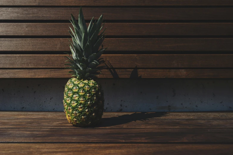 a pineapple sitting on top of a wooden table, unsplash, sitting on a bench, background image, alessio albi, various posed