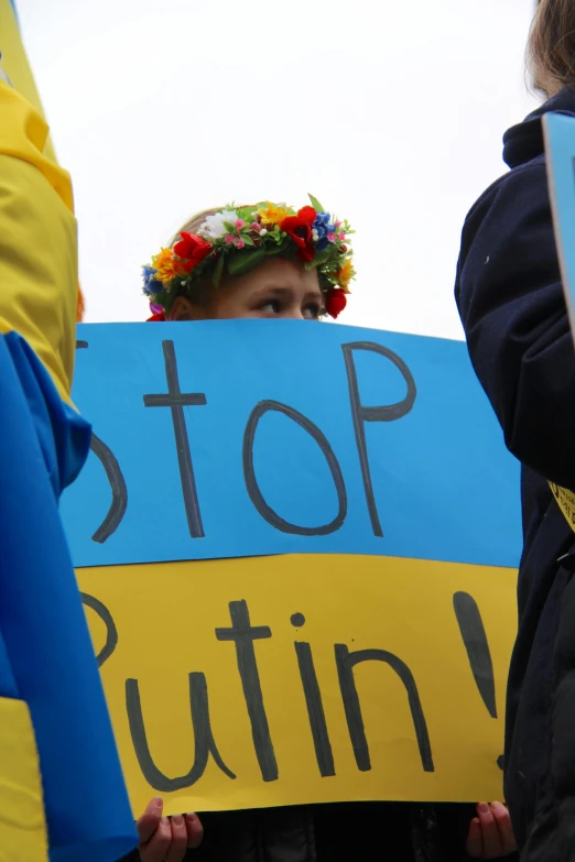 a group of people holding signs that say stop cutting, flickr, stuckism, with yellow flowers around it, ukrainian girl, photo of putin, yellow and blue