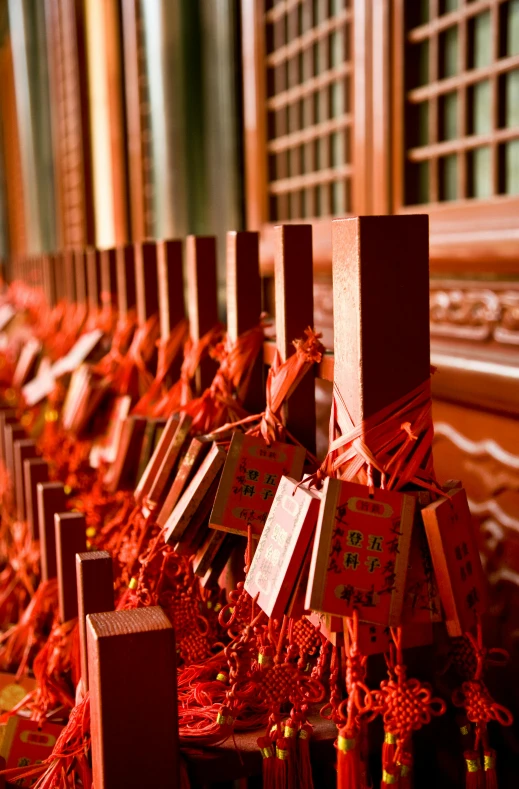 a row of red boxes sitting on top of a table, inspired by Torii Kiyomoto, sōsaku hanga, chinese temple, zippers, fine details. red, pray