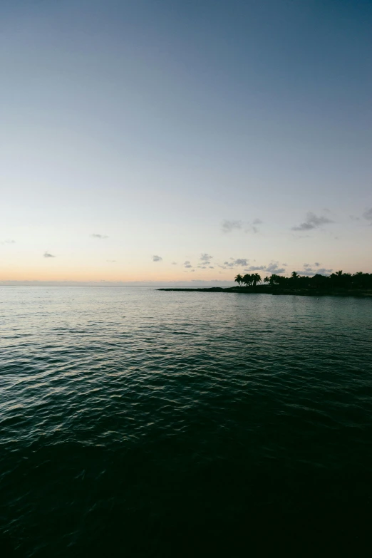 a body of water with a small island in the distance, unsplash, puerto rico, dawn and dusk, low ultrawide shot, clean image