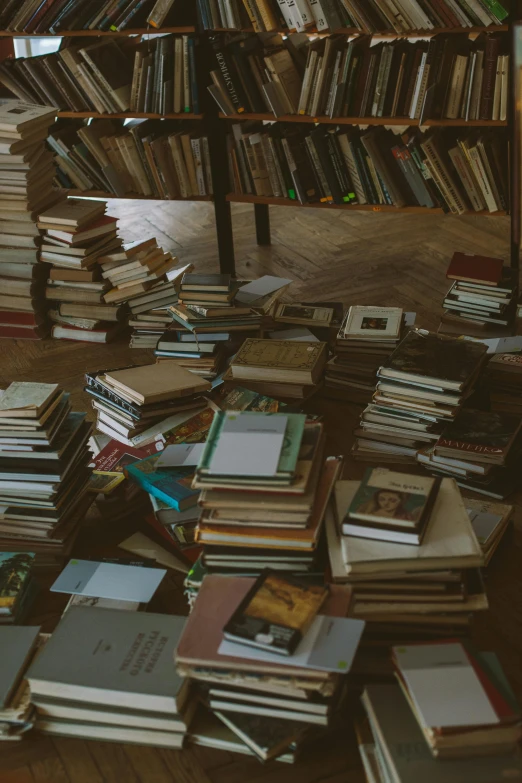 a pile of books sitting on top of a wooden floor, trending on unsplash, happening, thrown tables, spiral shelves full of books, mess, promo image