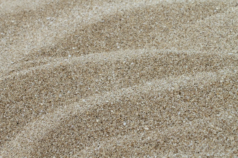 a pile of sand sitting on top of a sandy beach, inspired by Andreas Gursky, beige, low detail, mixed art, platinum