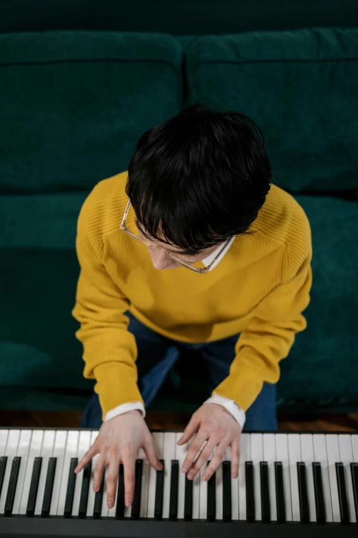 a person sitting on a couch playing a piano, shin hanga, nerdy music teacher with phd, declan mckenna, ((tatsuro yamashita))