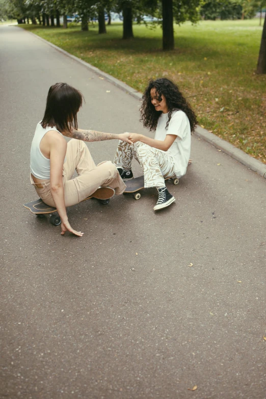 a couple of women sitting on top of a skateboard, inspired by Elsa Bleda, trending on pexels, in a square, holding hand, high quality photo, hila klein