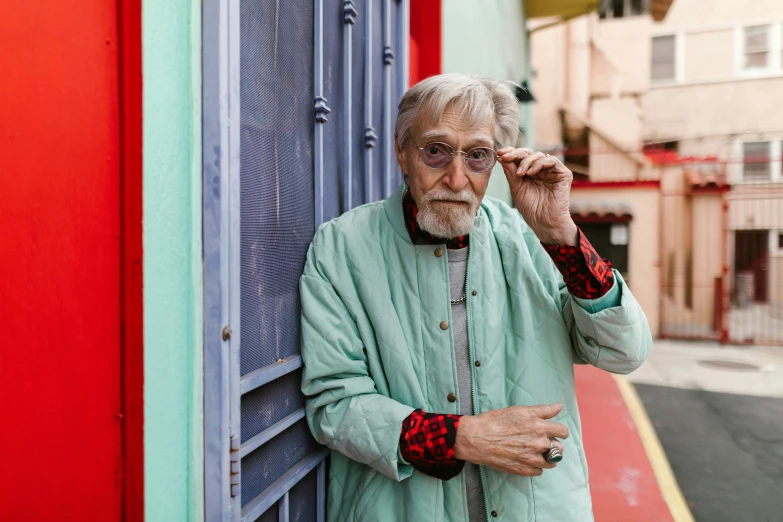 an older man leaning against the side of a building, an album cover, inspired by John Bellany, pexels contest winner, hyperrealism, style of wes anderson, multicolored, old lady, al pacino