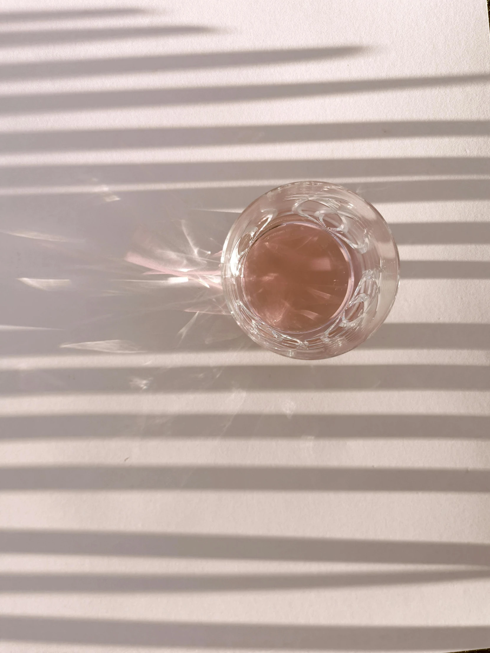 a glass of water sitting on top of a table, by Rebecca Horn, unsplash, light and space, pink shadows, taken on iphone 14 pro, transparent corrugated glass, ilustration