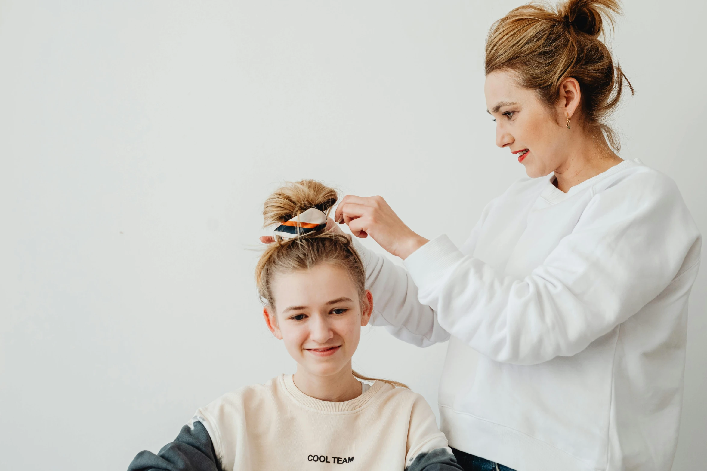 a woman getting her hair done by a hair stylist, by Emma Andijewska, trending on pexels, hurufiyya, caring fatherly wide forehead, teenage boy, wearing a cute top, diadems