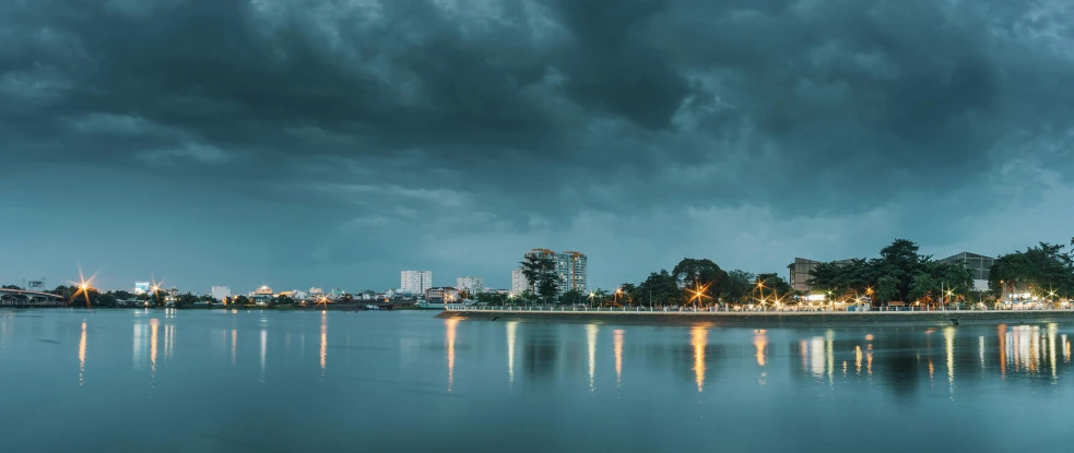 a large body of water under a cloudy sky, by Joze Ciuha, pexels contest winner, futuristic phnom-penh cambodia, storm in the evening, city park, panoramic photography