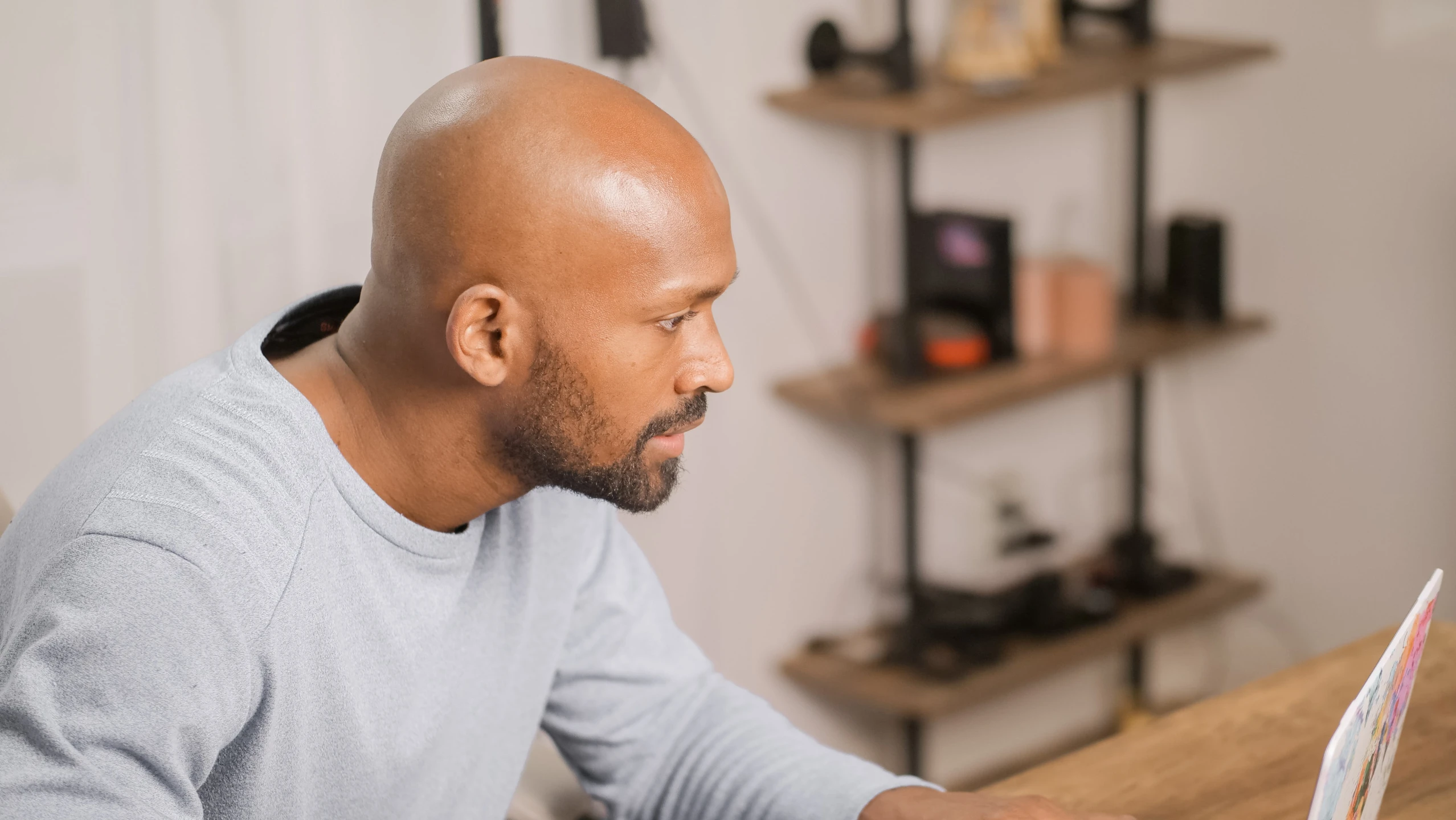 a man sitting at a table using a laptop computer, profile image, atiba jefferson, colour corrected, balding older cyborg repairing