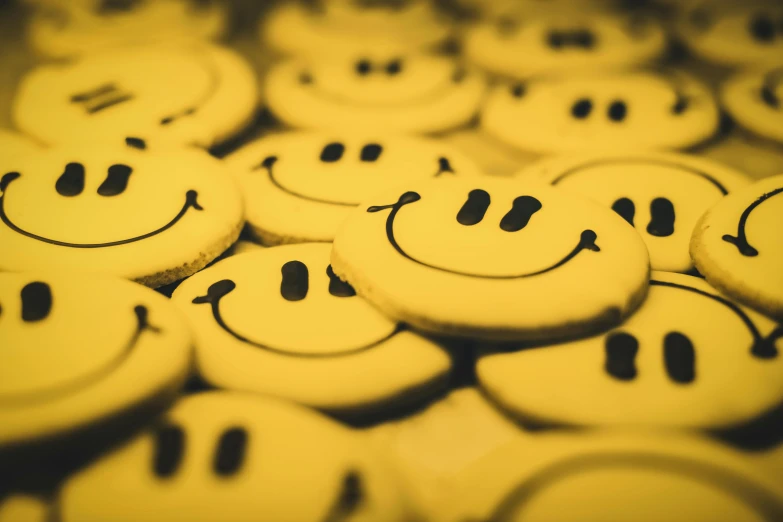 a bunch of smiley face cookies sitting on top of each other, by Niko Henrichon, pexels, yellow and black, avatar image, good vibrations, small smile